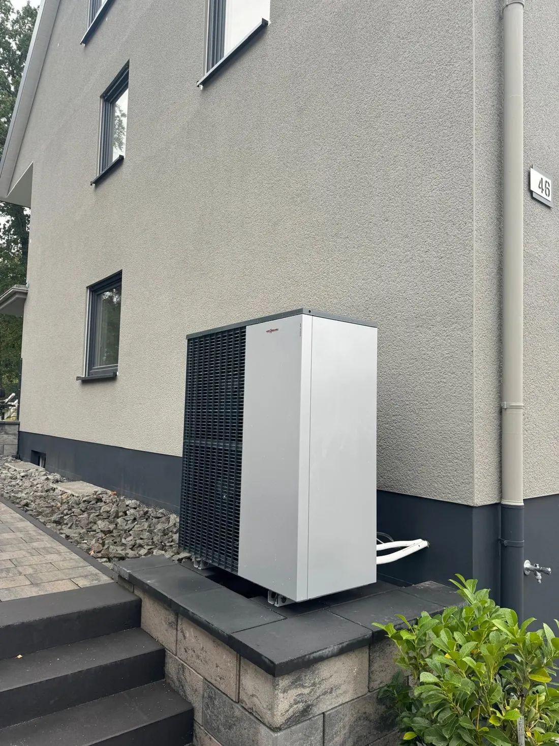 Luft-Wärmepumpe an der Hauswand eines Einfamilienhauses